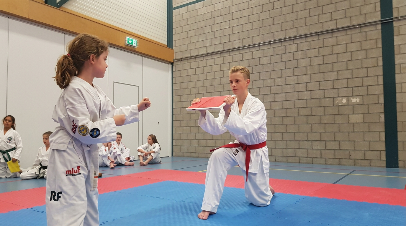 Taekwon-Do lid slaat een breekplank stuk die wordt vastgehouden